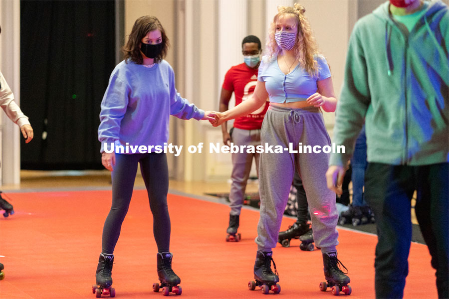 Students hold hands as they skate during the Club 80 Roller Skating Event in the Nebraska Union Ballroom on Friday, February 19, 2021, in Lincoln, Nebraska. Photo by Jordan Opp for University Communication.