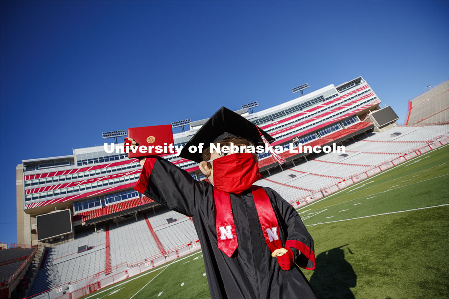 A masked Herbie Husker holding a diploma, poses in regalia to announce spring commencement will be in Memorial Stadium. March 1, 2021. Photo by Craig Chandler / University Communication.