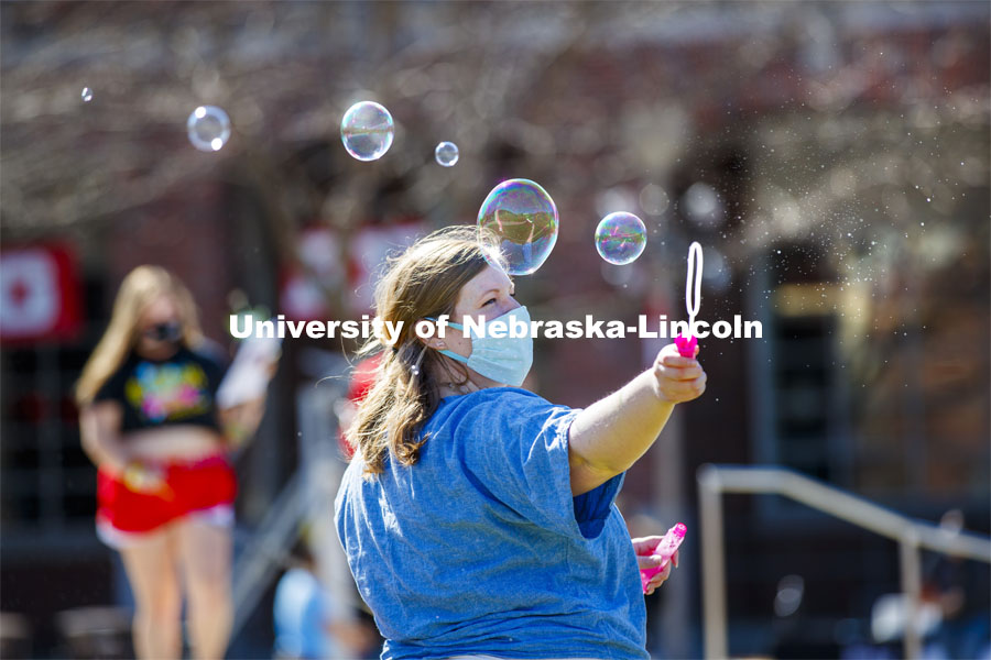 Lanie Stutz, CARE Advocate for Student Affairs, blows bubbles outside the Nebraska Union.  Students have fun at the Spring Breakout, a midday festival with free games, music, and prizes. 300 free t-shirts for participants. March 29, 2021. Photo by Craig Chandler / University Communication.