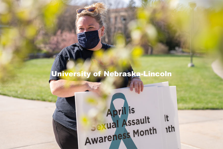 CARE Advocate Melissa Wilkerson speaks to volunteers before setting up their display at the Nebraska Union Greenspace. Flags and signs are placed in the Nebraska Union Greenspace to promote Sexual Assault Awareness Month. April 4, 2021. Photo by Jordan Opp for University Communication.
