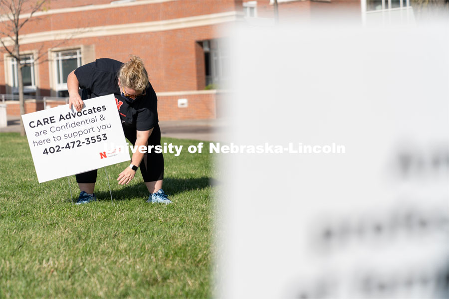 CARE Advocate Melissa Wilkerson places a sign at the Nebraska Union Greenspace. Flags and signs are placed in the Nebraska Union Greenspace to promote Sexual Assault Awareness Month. April 4, 2021. Photo by Jordan Opp for University Communication.