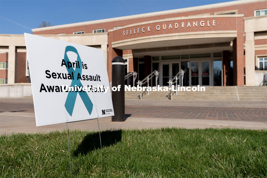 A sign recognizing April as sexual assault awareness month is placed on the Nebraska Union Greenspace. Flags and signs are placed in the Nebraska Union Greenspace to promote Sexual Assault Awareness Month. April 4, 2021. Photo by Jordan Opp for University Communication.