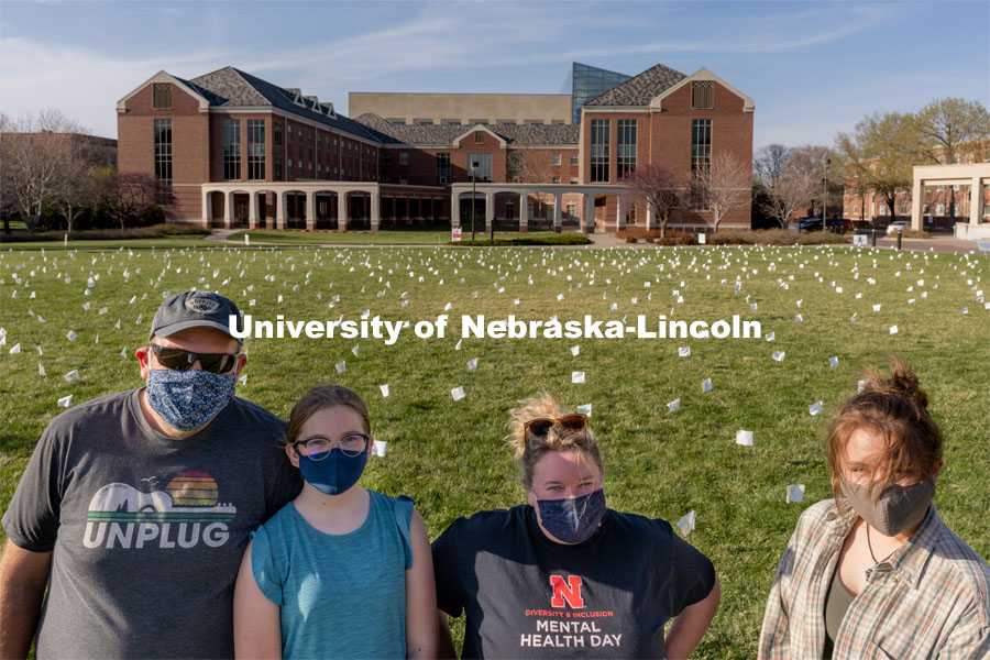 Left to right: Matt Milner, McClellan Milner, Melissa Wilkerson and Violet Hudson pose for a portrait in front of their display at the Nebraska Union Greenspace. Flags and signs are placed in the Nebraska Union Greenspace to promote Sexual Assault Awareness Month. April 4, 2021. Photo by Jordan Opp for University Communication.