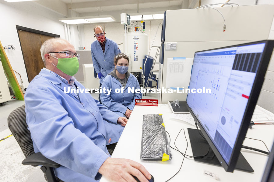 Dan Draney, Pat Dussault, and Michelle Takacs look over results from the Research Instrumentation Facility’s high-field NMR (nuclear magnetic resonance) spectrometer in Hamilton Hall. April 6, 2021. Photo by Craig Chandler / University Communication.