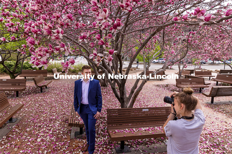 Lucas Zelnio has his photo taken by Avery Bowman under the Saucer Magnolia trees blooming outside of the Lied Center. Spring on City Campus. April 6, 2021. Photo by Craig Chandler / University Communication.
