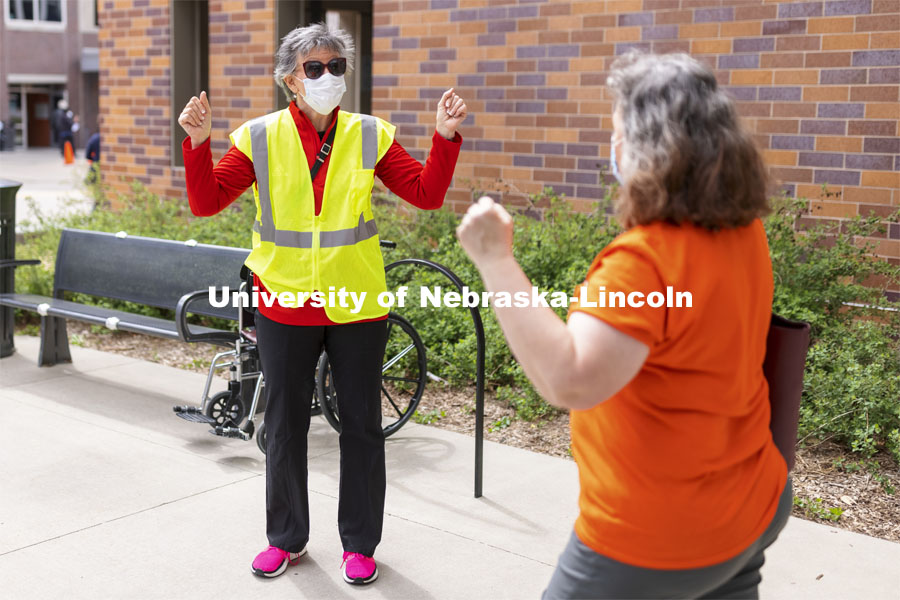 Jane Green cheers with a vaccinated person leaving the clinic Friday afternoon. Chancellor Ronnie Green and Jane Green volunteer Friday afternoon at the COVID Vaccine Clinic at Pinnacle Bank Arena. April 9, 2021. Photo by Craig Chandler / University Communication.