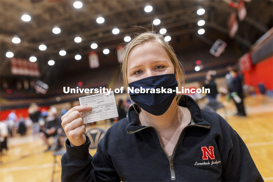 Whitney Steckel shows her vaccine card during Tuesday’s clinic. Vaccine clinic in the Coliseum with a free food and goodies tent outside. April 20, 2021. Photo by Craig Chandler / University Communication.  
