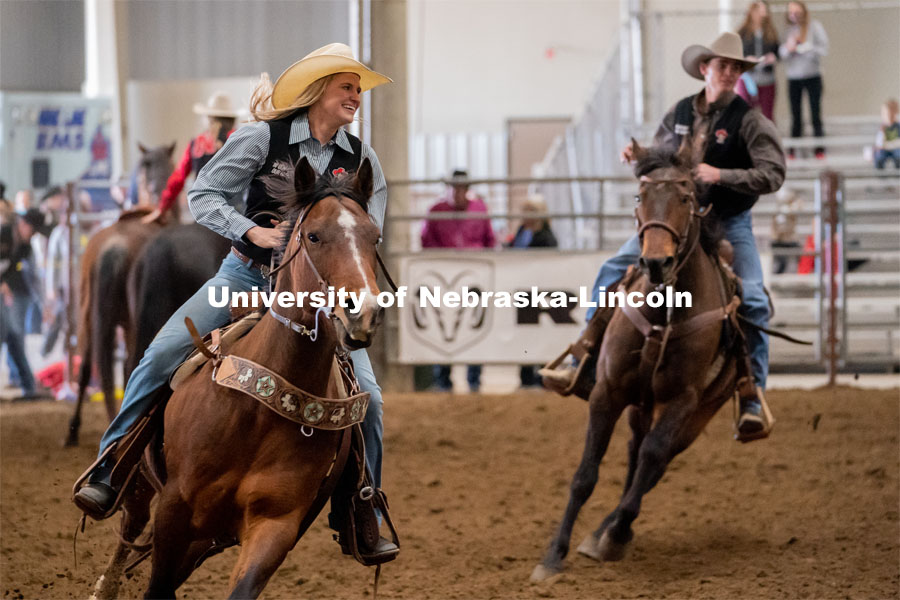 Members of the University of Nebraska rodeo team runs onto the track at the Nebraska Cornhusker College Rodeo at the Lancaster Event Center. April 24, 2021. Photo by Jordan Opp for University Communications.