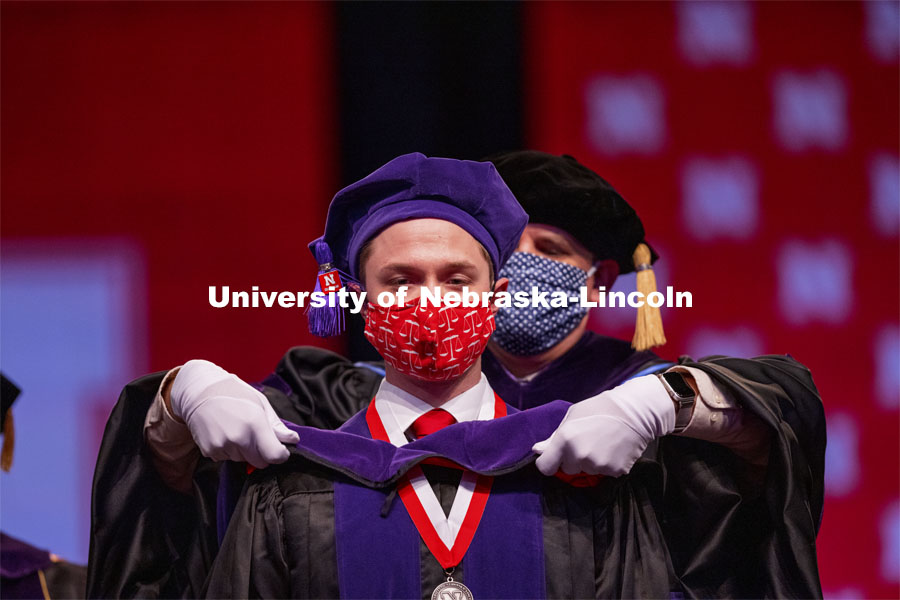 Samuel Baue receives his hood during College of Law Graduation at Pinnacle Bank Arena. May 7, 2021. Photo by Craig Chandler / University Communication.