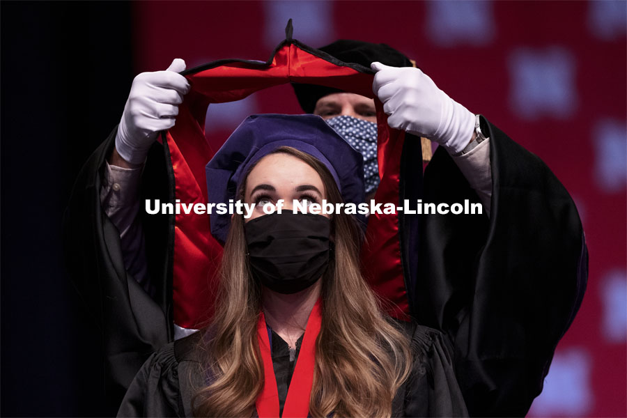 Emily Coffey eyes the prize as her doctoral hood is lowered over her head. College of Law Graduation at Pinnacle Bank Arena. May 7, 2021. Photo by Craig Chandler / University Communication.