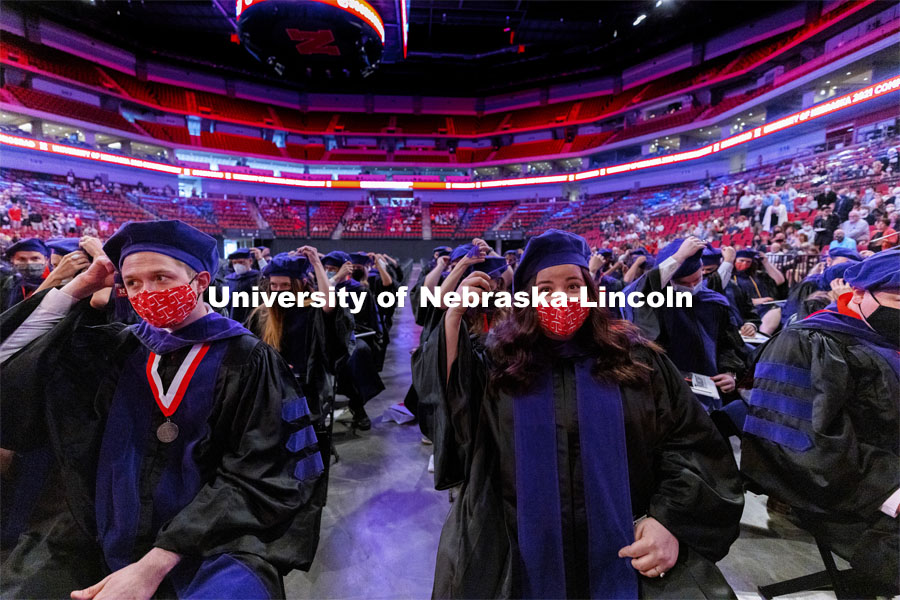 Samuel Baue, left, and Anna Bauerie move their tassels on their tams following graduations. College of Law Graduation at Pinnacle Bank Arena. May 7, 2021. Photo by Craig Chandler / University Communication.
