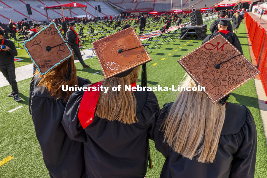 CASNR graduates Jacque Stauffer, Abby Durheim and McCyla Mickelson wore leather tooled mortar board decorations. UNL Commencement in Memorial Stadium. May 8, 2021. Photo by Craig Chandler / University Communication.