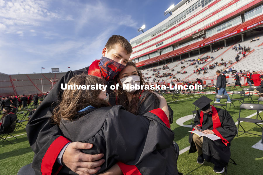Sarah Osborn, Mathias Schulte and Victoria Banister share a final hug before the start of the morning ceremony. UNL Commencement in Memorial Stadium. May 8, 2021. Photo by Craig Chandler / University Communication.