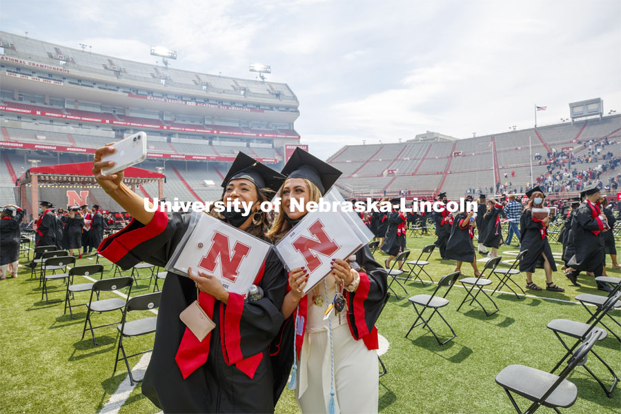 Ana Rodriguez and Brooke Lamkins take a selfie after the morning commencement. UNL Commencement in Memorial Stadium. May 8, 2021. Photo by Craig Chandler / University Communication.