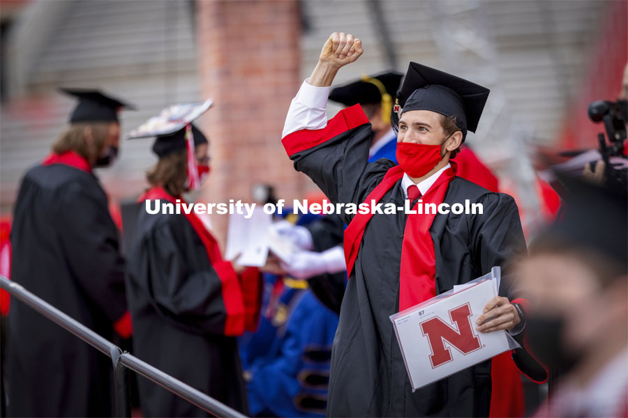 Alfred Grovas gestures to his family and friends in the stadium after receiving his engineering diploma. The university conferred a record 3,594 degrees during the May commencement ceremonies. UNL Commencement in Memorial Stadium. May 8, 2021. Photo by Craig Chandler / University Communication.