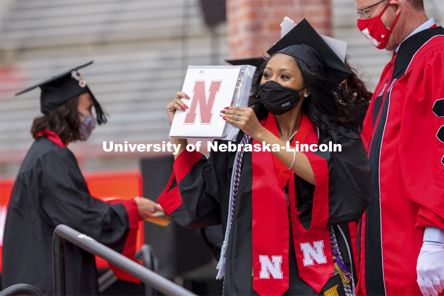 Grad gestures to her family and friends in the stadium after receiving her diploma. The university conferred a record 3,594 degrees during the May commencement ceremonies. UNL Commencement in Memorial Stadium. May 8, 2021. Photo by Craig Chandler / University Communication.