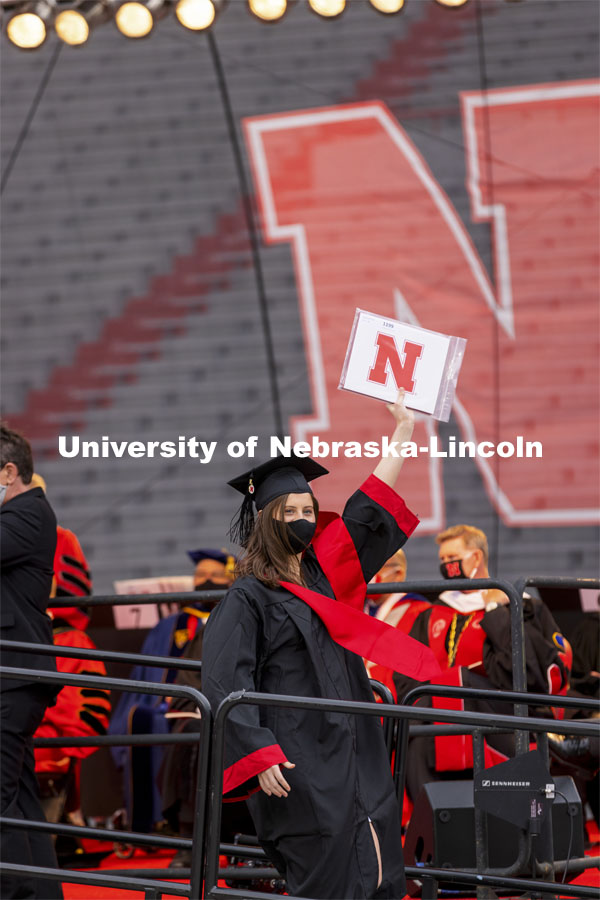 Grad holds up dipoloma as she walks off stage. The university conferred a record 3,594 degrees during the May commencement ceremonies. UNL Commencement in Memorial Stadium. May 8, 2021. Photo by Craig Chandler / University Communication.