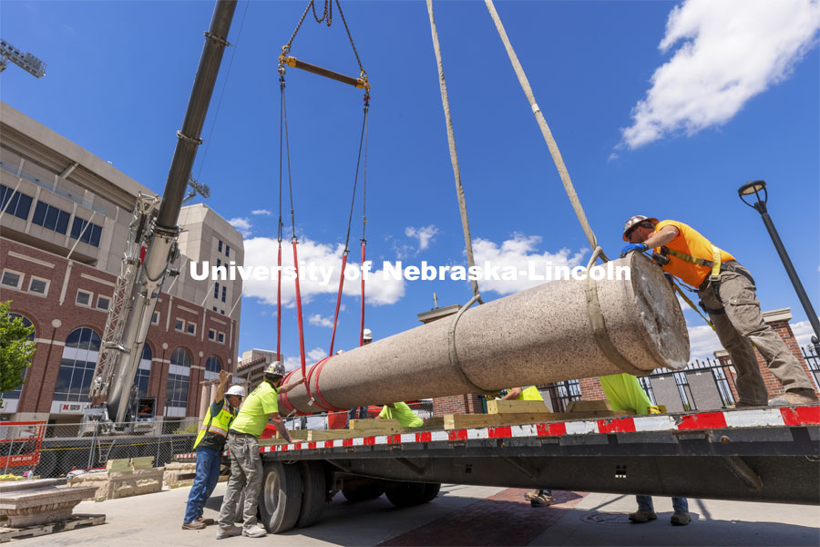 A column’s shaft is lowered onto a trailer outside East Stadium. The columns outside of Memorial Stadium are being removed to make way for the new athletics complex. They are being stored until a new site is developed on campus. May 12, 2021. Photo by Craig Chandler / University Communication.