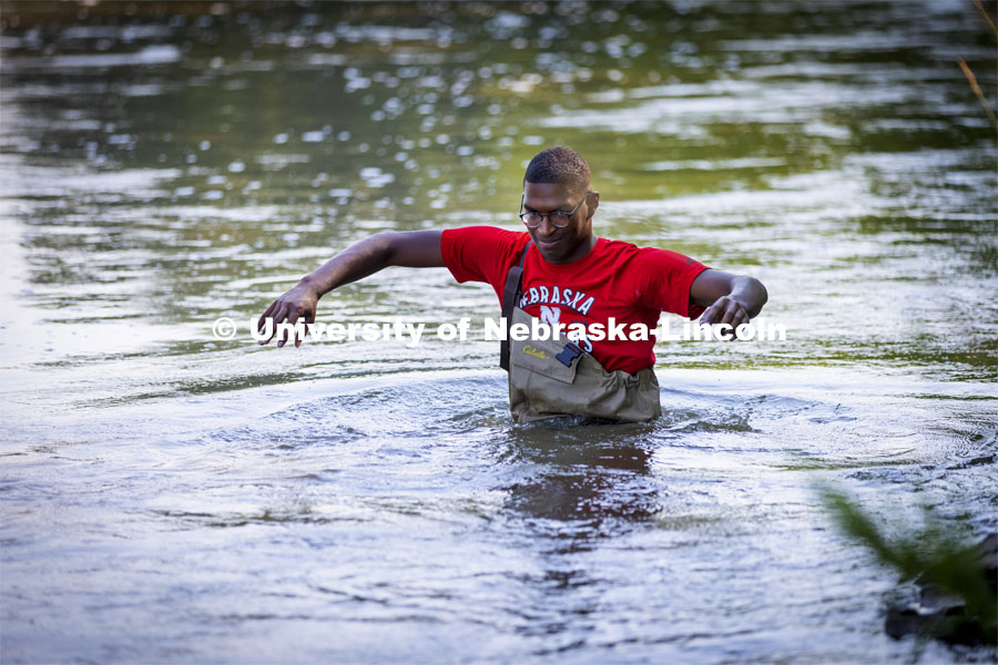 McNair scholar Seth Caines, wades into the water to sample water in the Elkhorn River. He is working with Professor Shannon Bartlet-Hunt researching textiles as a source of microplastic fibers to Nebraska streams. July 2, 2021. Photo by Craig Chandler / University Communication.