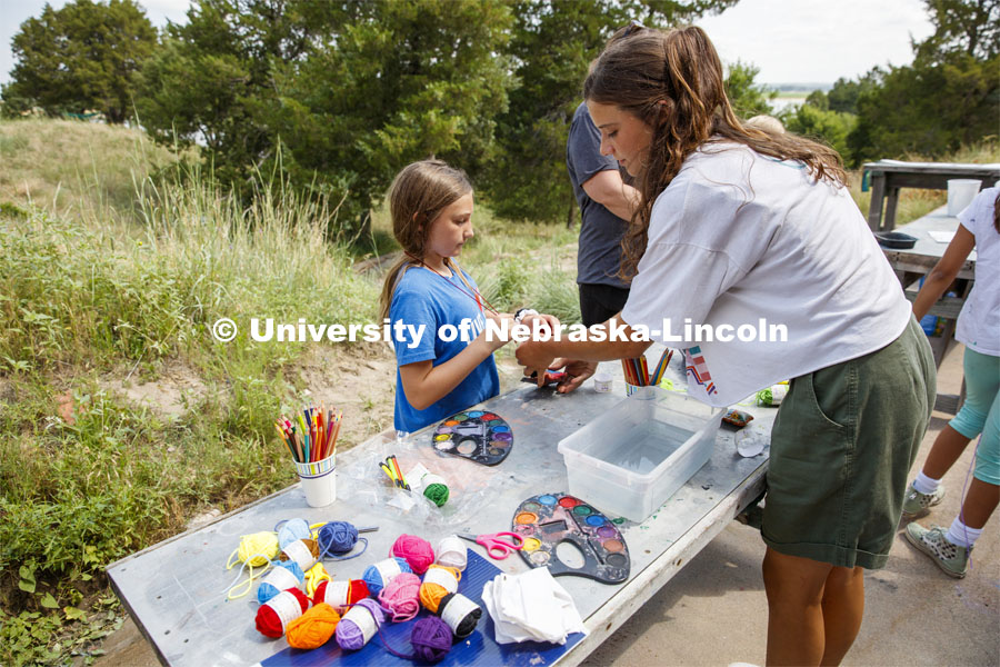 Joselyn Andreasen, a sophomore at Nebraska, helps a camper tie a string on her clay pouch. Cedar Point Biological Station near Ogallala, Nebraska. July 19, 2021. Photo by Annie Albin / University Communication.