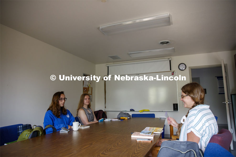 Sarah Hawkinson (blue shirt) and Kaylen Michaelis (tank top) discuss the first few chapters of “O Pioneers!” with their instructor, Emily Rau.Studying Willa Cather at Cedar Point Biological Station near Ogallala, Nebraska. July 19, 2021. Photo by Annie Albin / University Communication