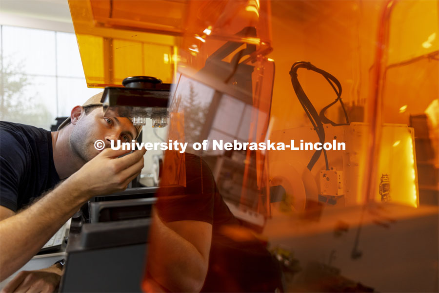 Adan Redwine, a graduate student in Biological Systems Engineering, checks the 3-D printing of his neuron culture system parts for his work in Rebecca Wachs’ lab. Nebraska Innovation Campus. August 10, 2021. Photo by Craig Chandler / University Communication.