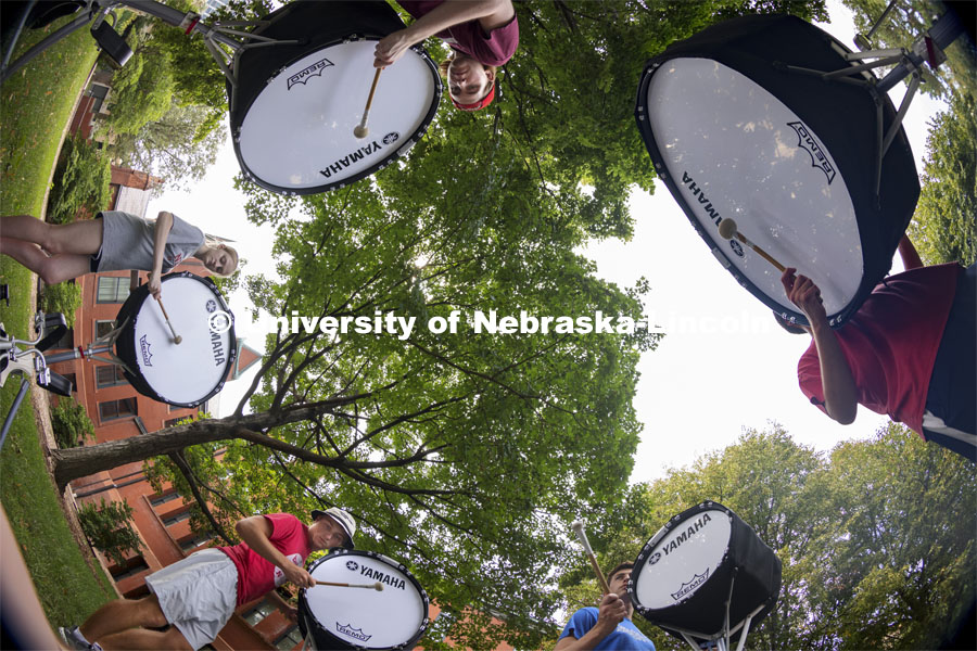 The Cornhusker Marching Band percussion groups kick off the school year. Base drums practice in the shade by Architecture Hall. Clockwise from lower right is Carter Ross, Cole Asche, Abby Reasoner, Alaric Schiltz, and Jansen Coburn. August 12, 2021. Photo by Craig Chandler / University Communication.