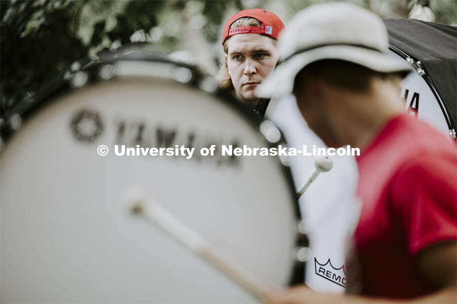 The Cornhusker Marching Band percussion groups kick off the school year. Alaric Schiltz and the other base drums practice in the shade by Architecture Hall. August 12, 2021. Photo by Craig Chandler / University Communication.