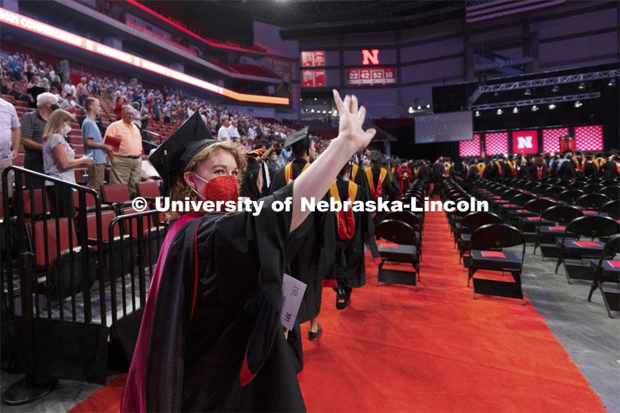 Emma Loberg waves to family and friends as the soon-to-be speech-language pathology masters degree recipient enters Pinnacle Bank Arena. Summer Graduate Commencement at Pinnacle Bank Arena. August 13, 2021. Photo by Craig Chandler / University Communication.
