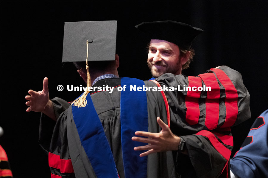 2020 graduate Alex Rosa hugs Professor Rodrigo Werle after Rosa returned to campus to receive his doctoral hood. Summer Graduate Commencement at Pinnacle Bank Arena. August 13, 2021. Photo by Craig Chandler / University Communication.