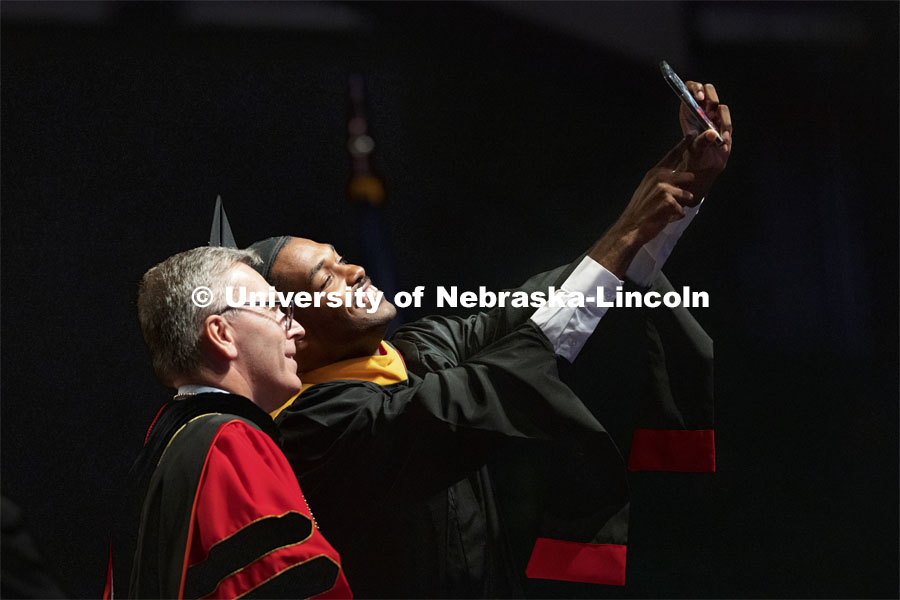 Kailon Lang takes a selfie on stage with Chancellor Ronnie Green after Lang received his masters degree in agronomy. Summer Graduate Commencement at Pinnacle Bank Arena. August 13, 2021. Photo by Craig Chandler / University Communication.