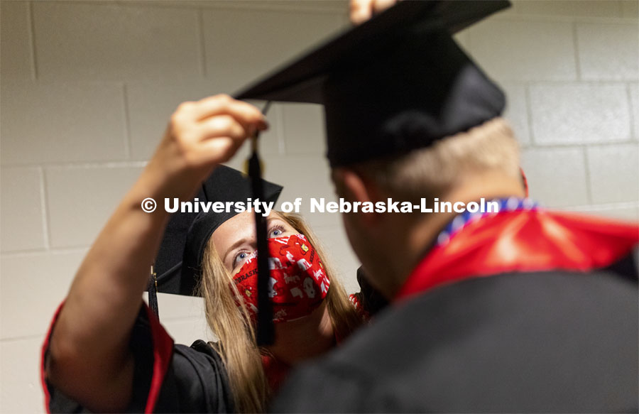 Lindsey LaBrie attaches Braden Wojahn’s tassel before the undergraduate commencement. Undergraduate Commencement at Pinnacle Bank Arena. August 14, 2021. Photo by Craig Chandler / University Communication.