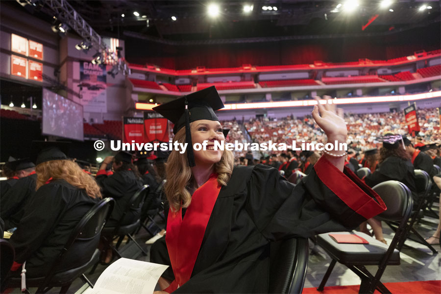 Alexandria Warneke waves to her family and friends in the audience at the Undergraduate Commencement at Pinnacle Bank Arena. August 14, 2021. Photo by Craig Chandler / University Communication.