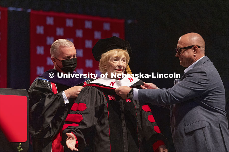 Leta Powell Drake, local television pioneer and Husker alumna, is hooded by NU Regent Tim Clare and Drakes, son, Aaron. Drake was presented with an honorary Doctor of Humane Letters during the undergraduate ceremony. Undergraduate Commencement at Pinnacle Bank Arena. August 14, 2021. Photo by Craig Chandler / University Communication.