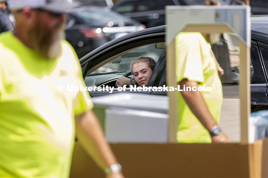 Robin Lindemann, a First Husker from Arlington, TX, watches as her belongings are unloaded from her car outside of Harper, Schramm, Smith residence halls. Early arrival move-in for sorority rush, First Husker and Emerging Leaders. August 15, 2021. Photo by Craig Chandler / University Communication.