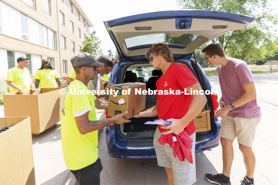 Seth Wright, a freshman from Petersburg, Nebraska, hands over a box to the move-in crew at Massengale Residence Hall. Residence halls move in. August 17, 2021. Photo by Craig Chandler / University Communication.