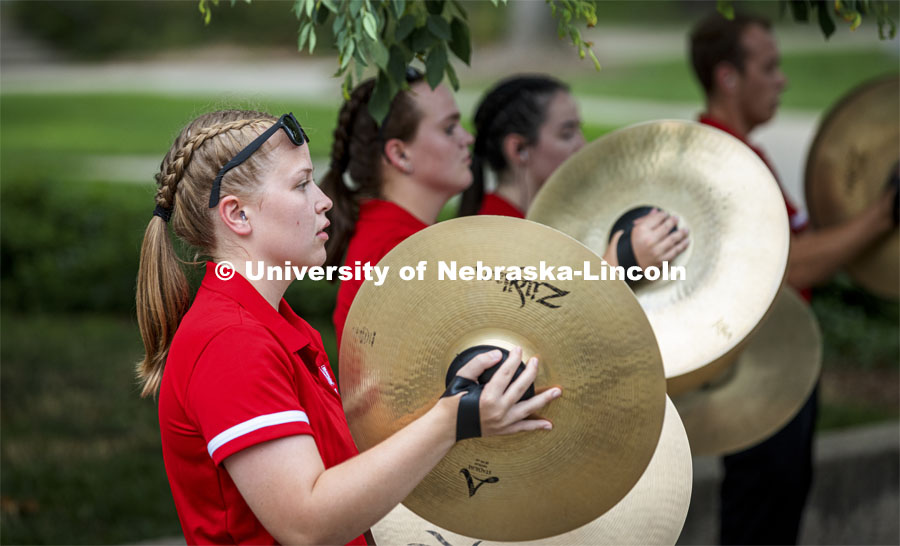 Kelly Fedderson and the rest of the cymbal line performs before the Cornhusker Marching Band Exhibition. Big Red Welcome week featured the Cornhusker Marching Band Exhibition. The band gave their warm-up concert outside of Kimball Recital Hall and then marched to the stadium. Lightning then caused the show to be cancelled. August 20, 2021. Photo by Craig Chandler / University Communication.