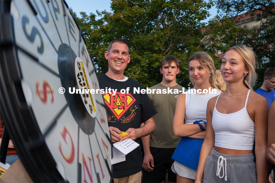 Students take turns spinning a wheel to try and win free prizes during the Big Red Welcome Street Festival. The Street Festival was held on East Memorial Stadium Loop between the College of Business and Memorial Stadium. August 22, 2021. Photo by Jordan Opp for University Communication.
