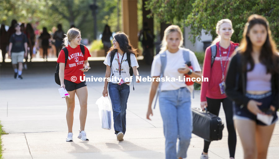 Korrina Niemann of Wayne, Nebraska, and Alexis Rutar of Springview, Nebraska, enjoy a laugh as they head for their first class of the day. First day of classes for fall semester. August 23, 2021. Photo by Craig Chandler / University Communication.