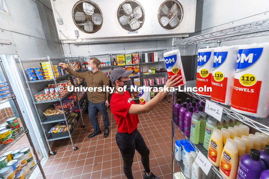Morgan Berg, a senior in psychology from West Fargo, North Dakota, and Tim Anderson, a third-year law student from Huntington Beach, California, stock the shelves in the new East Campus Food Pantry. The pantry is in Filley Hall in the old Dairy Store walk-in freezer. August 31, 2021. Photo by Craig Chandler / University Communication.