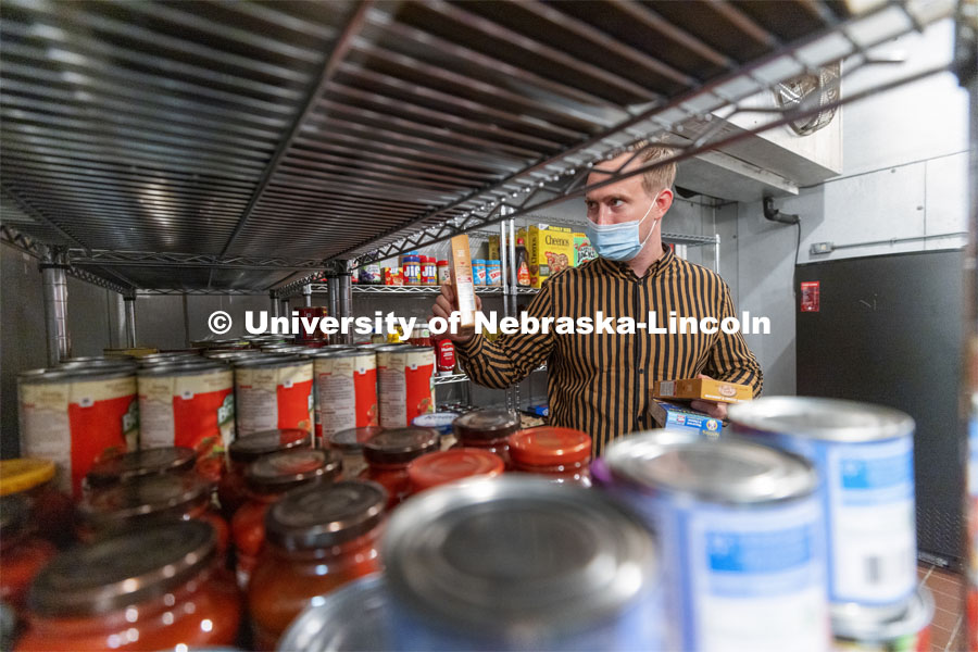 Tim Anderson, a third-year law student from Huntington Beach, California, stocks the shelves in the new East Campus Food Pantry. The pantry is in Filley Hall in the old Dairy Store walk-in freezer. August 31, 2021. Photo by Craig Chandler / University Communication.
