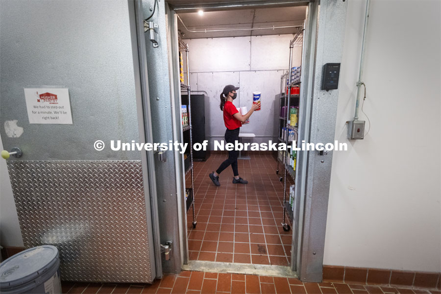 Morgan Berg, a senior in psychology from West Fargo, North Dakota, stocks the shelves in the new East Campus Food Pantry. The pantry is in Filley Hall in the old Dairy Store walk-in freezer. August 31, 2021. Photo by Craig Chandler / University Communication.