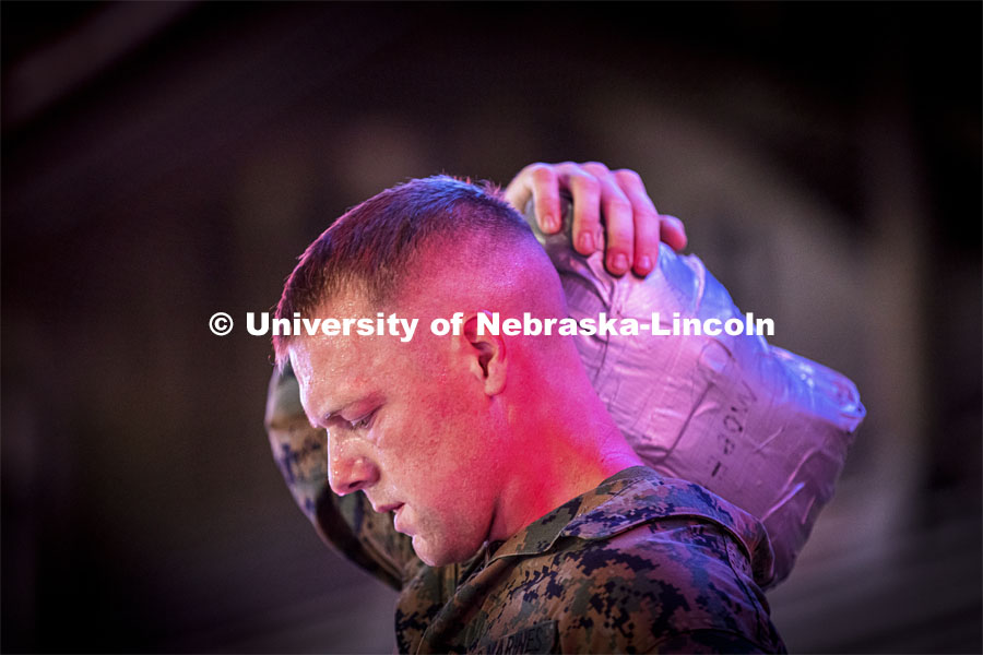 Staff Sargent Scott Johnson, an active-duty Marine who works with the NROTC program, carries a sandbag up and down the steps of the stadium. He said it weighed about 40 pounds. UNL ROTC cadets and Lincoln first responders run the steps of Memorial Stadium to honor those who died on 9/11. Each cadet ran more than 2,000 steps. September 9, 2021. Photo by Craig Chandler / University Communication.