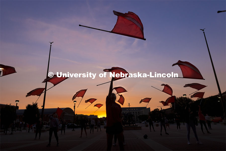 Cornhusker Marching Band Color Guard practices by dawn’s early light outside east stadium. September 9, 2021. Photo by Craig Chandler / University Communication.