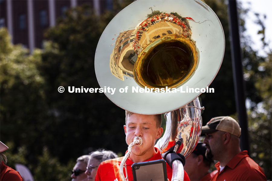Kason Fiedler, a senior from Lincoln, plays the sousaphone as the Cornhusker Marching Band warms up the crowd at the unity walk. Nebraska vs. Buffalo University game on the 20th anniversary of 9/11. Photo by Craig Chandler / University Communication.