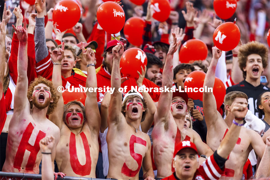 Fans with HUSKERS painted on their chests hold up their cell phone flashlights to light up the stands. Nebraska vs Northwestern University homecoming game. October 2, 2021. Photo by Craig Chandler / University Communication.