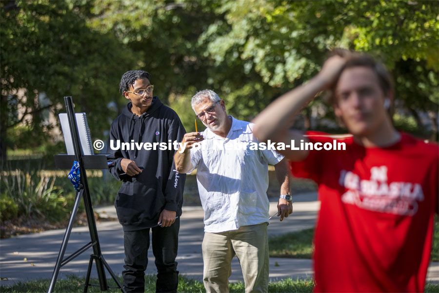 Chip Stanley works with Adham Westbrook on perspective and height during a class assignment. On a great fall day outside Architecture Hall, Chip Stanley’s DSGN 120 - Design Drawing class drew each other at various sizes to work on depth drawing. October 5, 2021. Photo by Craig Chandler / University Communication.