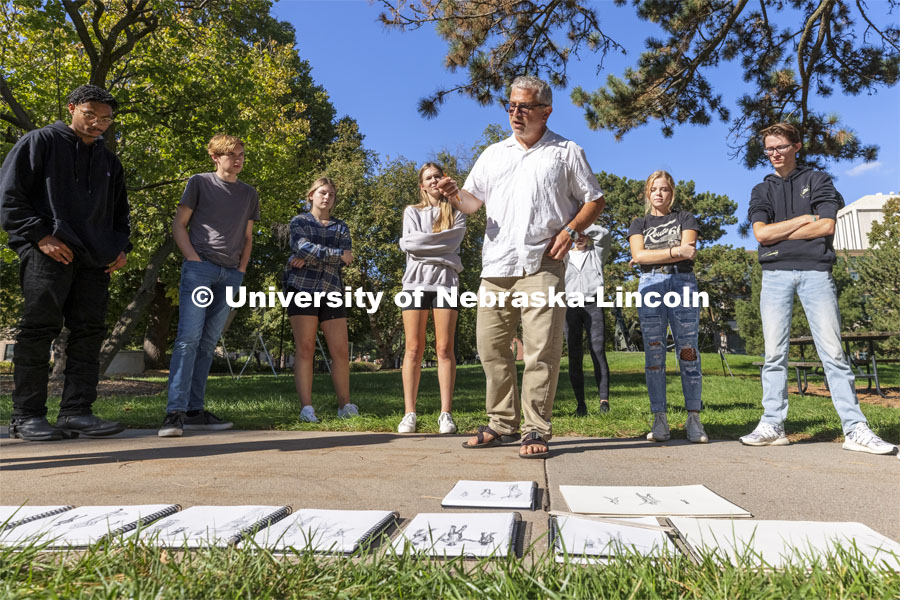 Chip Stanley critiques the class drawings. On a great fall day outside Architecture Hall, Chip Stanley’s DSGN 120 - Design Drawing class drew each other at various sizes to work on depth drawing. October 5, 2021. Photo by Craig Chandler / University Communication.