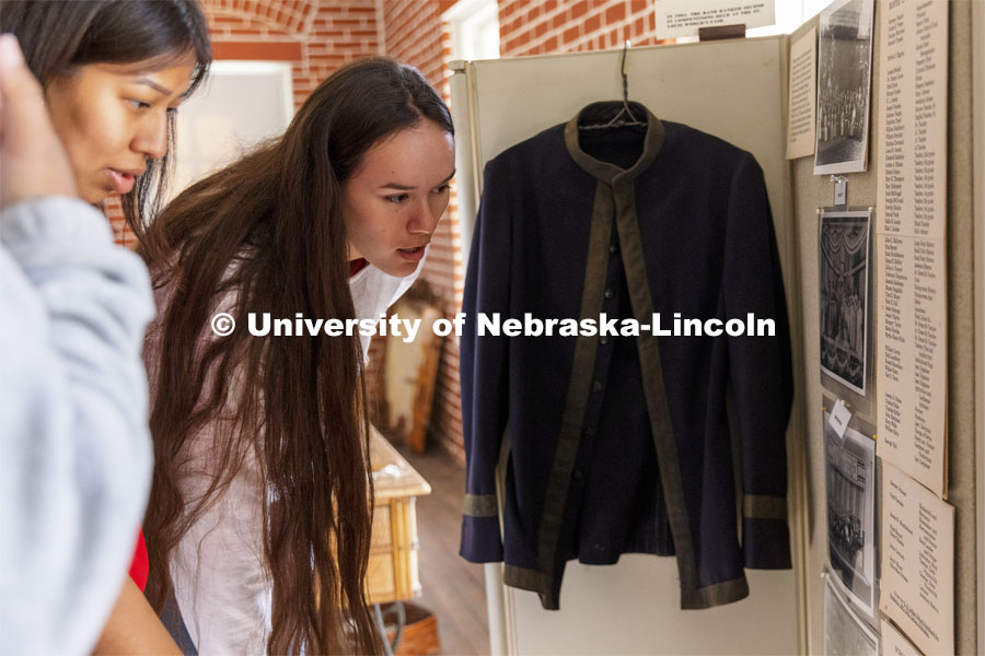 Jean Parker-Morris looks over a band uniform and school calendar that is part of the museum exhibits. Students from UNITE tour the Genoa Indian School in Genoa, Nebraska. October 10, 2021. Photo by Craig Chandler / University Communication.