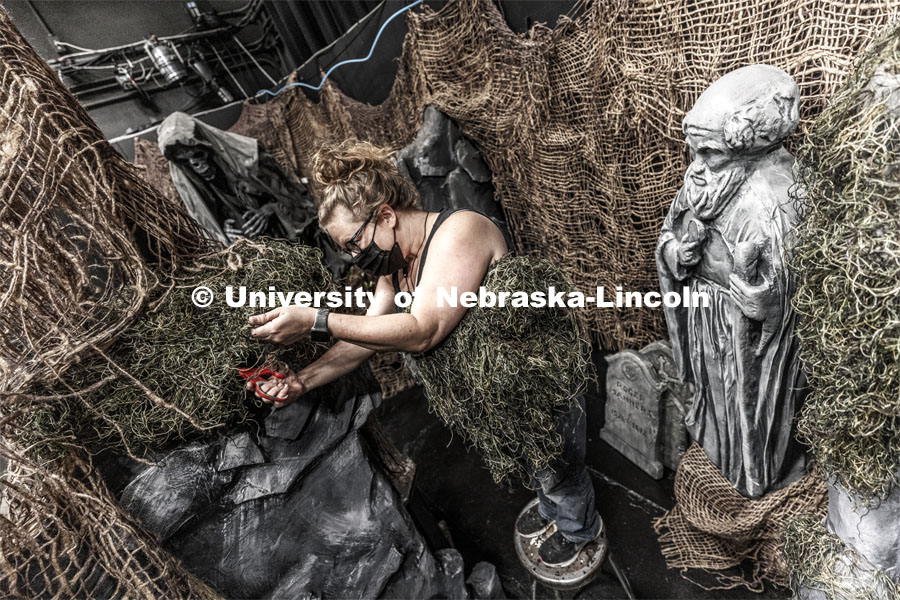 Production Designer Jill Hibbard works on the scenery in amongst the statuary. The Nebraska Repertory Theatre has turned Howell Theatre’s stage and backstage into a haunted house with a Shakespeare twist. ShakesFEAR opens October 15 and runs through Halloween. October 12, 2021. Photo by Craig Chandler / University Communication.
